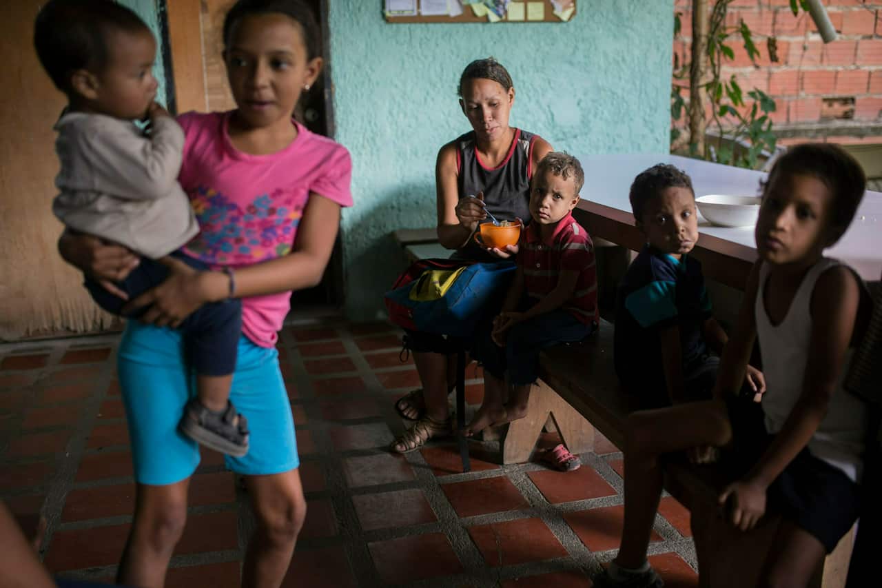 Francis Ojeda (centre) feeds her 4-year-old son Eduardo, in a soup kitchen in the Petare slum, in Caracas, Venezuela. 