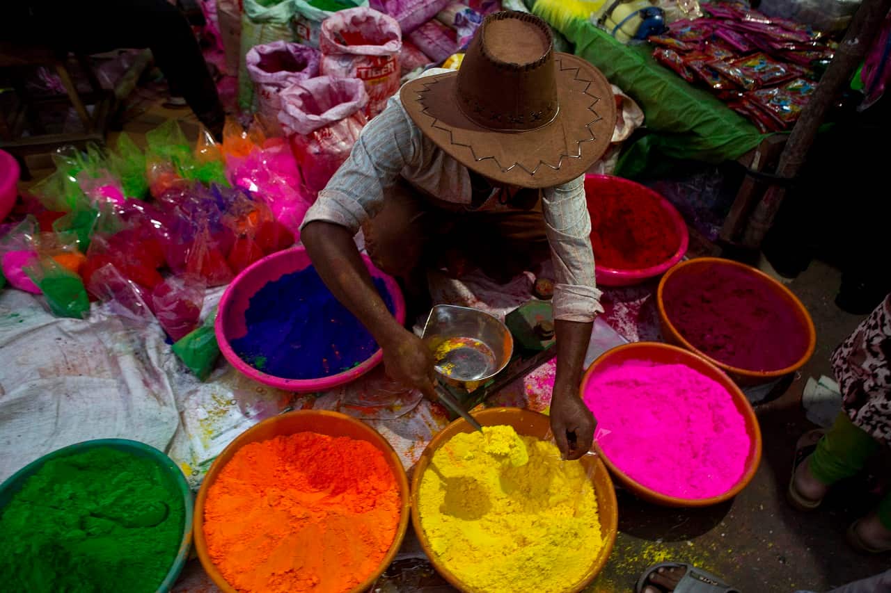 An Indian street vendor sells colored powder.
