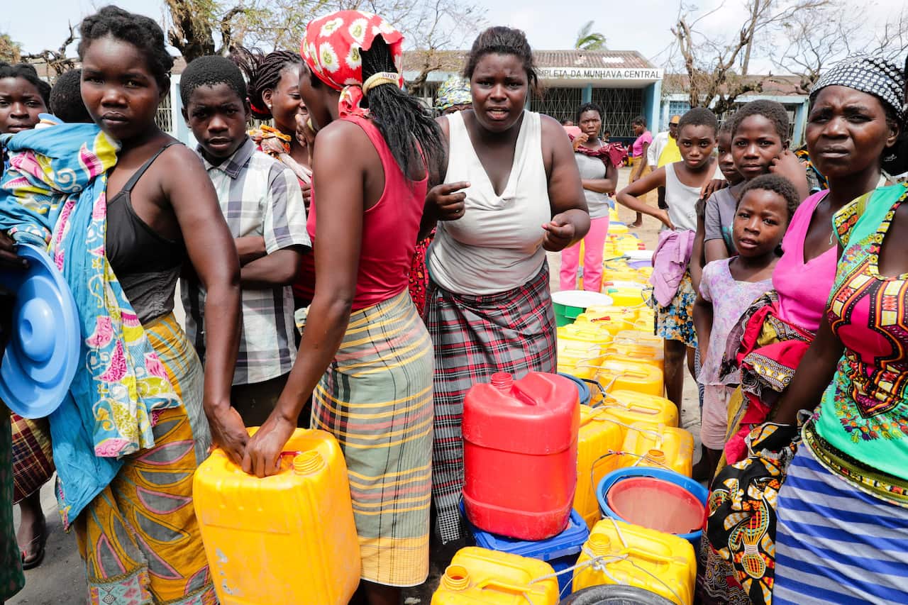 People wait to collect drinkable water delivered by local authorities that followed the passage of the cyclone Idai in Beira City, central Mozambique.