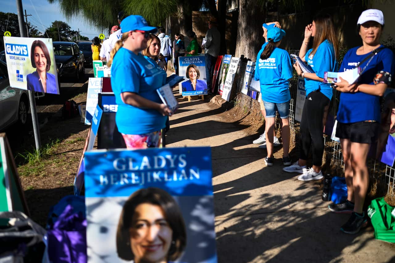 Volunteers are seen handing out how to vote cards at Willoughby Public School on 2019 New South Wales election day.