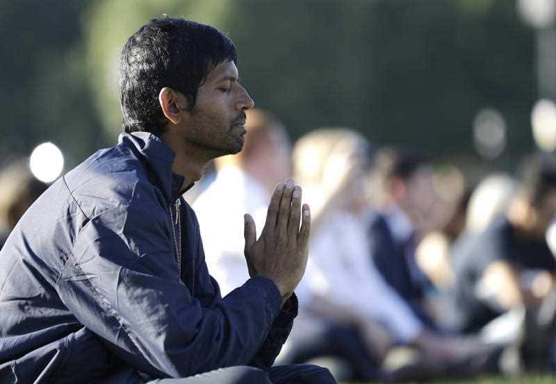 A man prays during a vigil in Hagley Park following the March 15 mass shooting in Christchurch, New Zealand