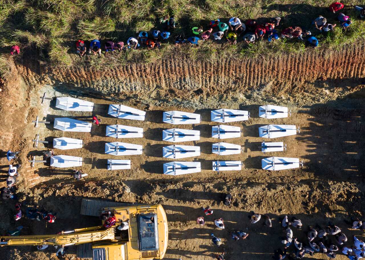 Coffins containing the bodies of flash floods victims are arranged in a grave during a mass burial in Sentani, Papua province, Indonesia.