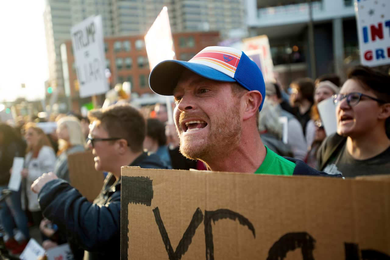 Jay Camp yells "lock him up" as he protests outside of President Donald Trump's rally at Van Andel Arena in Grand Rapids, Mich., on Thursday, March 28, 2019. (Neil Blake/MLive.com/The Grand Rapids Press via AP)