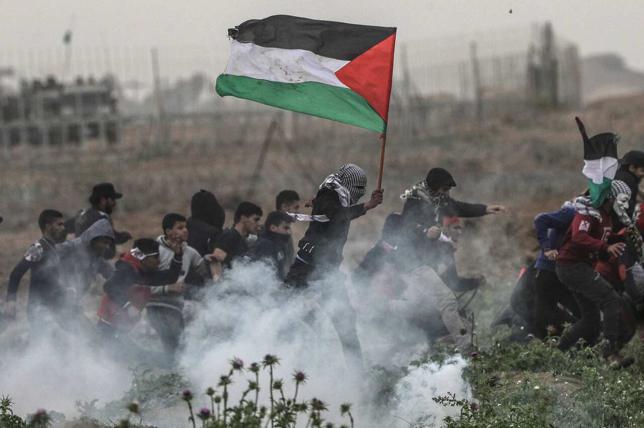 Palestinian protesters run for cover 