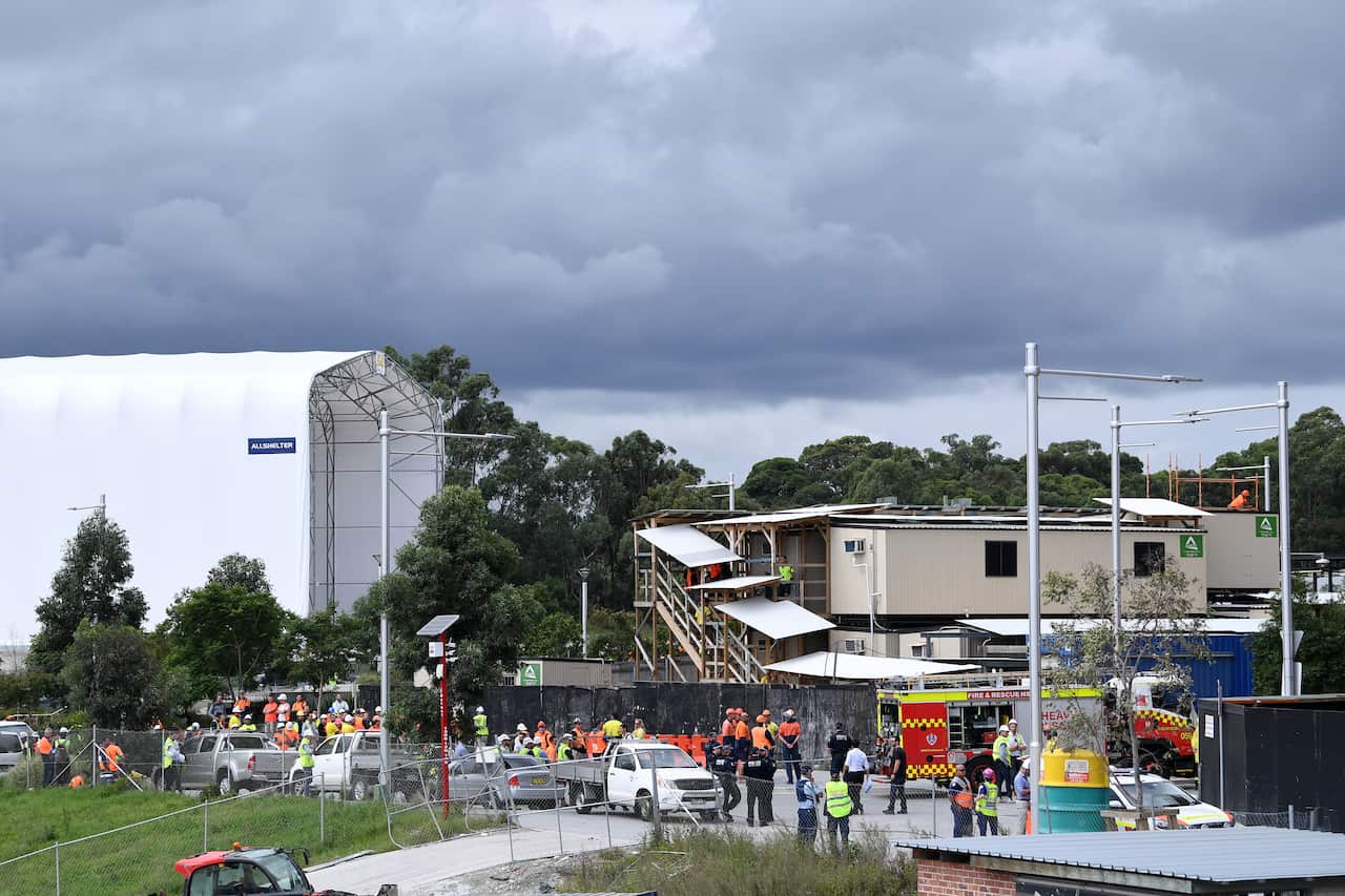 Rescue workers at the scene where a construction worker is trapped under scaffolding at a Macquarie Park worksite in Sydney's North, Monday, April 1, 2019. (AAP Image/Joel Carrett) NO ARCHIVING