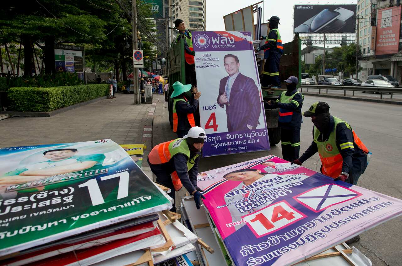 Workers load campaign billboards from the general election into a truck in Bangkok.