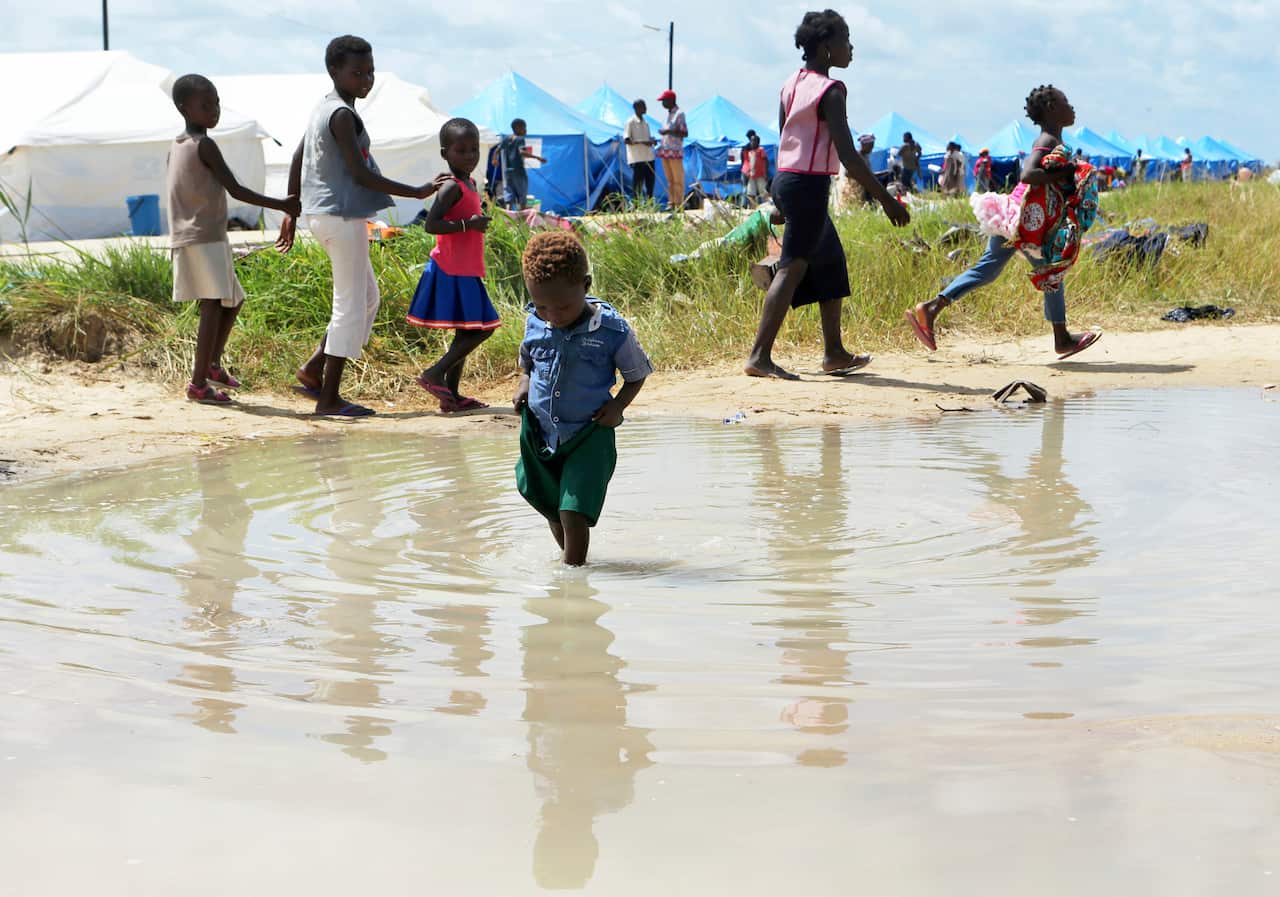 A child plays in a puddle at a camp for displaced survivors of cyclone Idai in Beira, Mozambique.