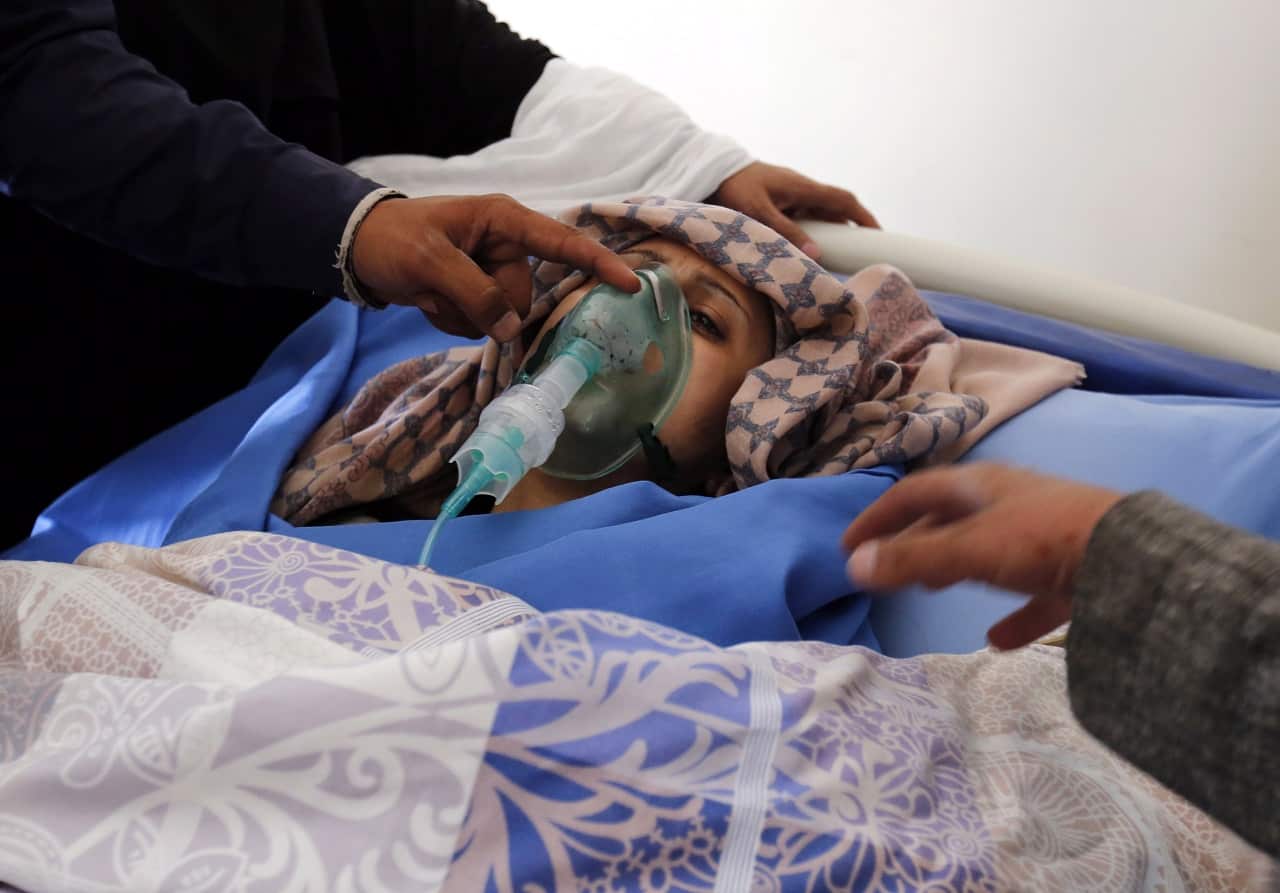 Yemenis gather around a wounded schoolgirl in Sanaa.