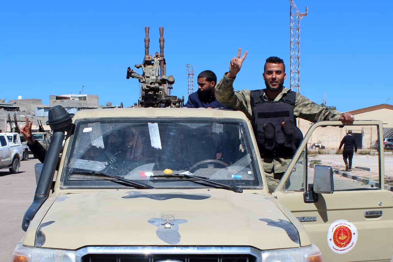 Militants, reportedly from the Misrata militia, flash the victory sign before joining forces defending the capital, in Tripoli, Libya, 8 April 2019. 