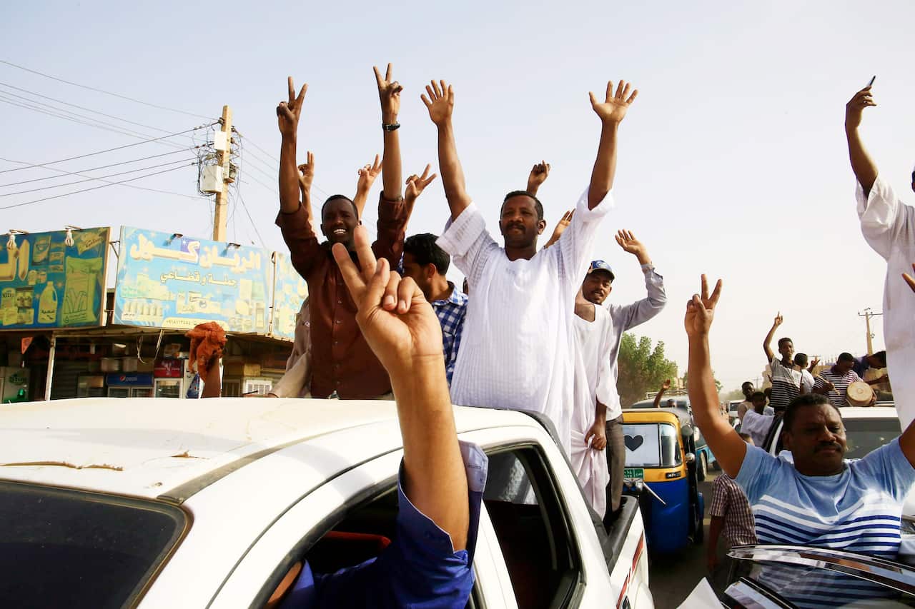 Sudanese people celebrate as they head towards the Army headquarters amid rumors that President Omar al-Bashir has stepped down.
