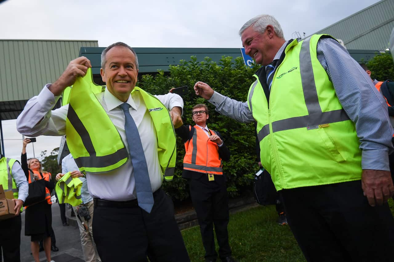 Australian Opposition Leader Bill Shorten puts on a high visibility vest during a visit to the Sydney Markets in Sydney, Friday, April 12, 2019.  (AAP Image/Lukas Coch) NO ARCHIVING