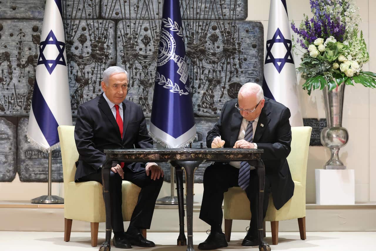 Israeli President Reuven Rivlin (R) signs a letter of appointment to Israeli Prime Minister and Chairman of the Likud Party Benjamin Netanyahu (R)