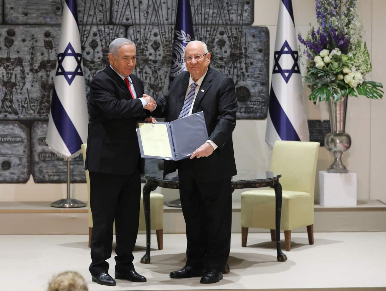 Israeli President Reuven Rivlin (R) hands a letter of appointment to Israeli Prime Minister and Chairman of the Likud Party Benjamin Netanyahu (L).