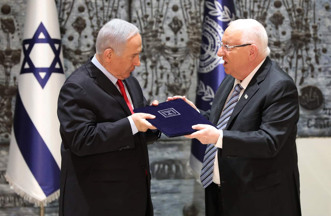 Israeli President Reuven Rivlin (R) hands a letter of appointment to Israeli Prime Minister and Chairman of the Likud Party Benjamin Netanyahu (R)