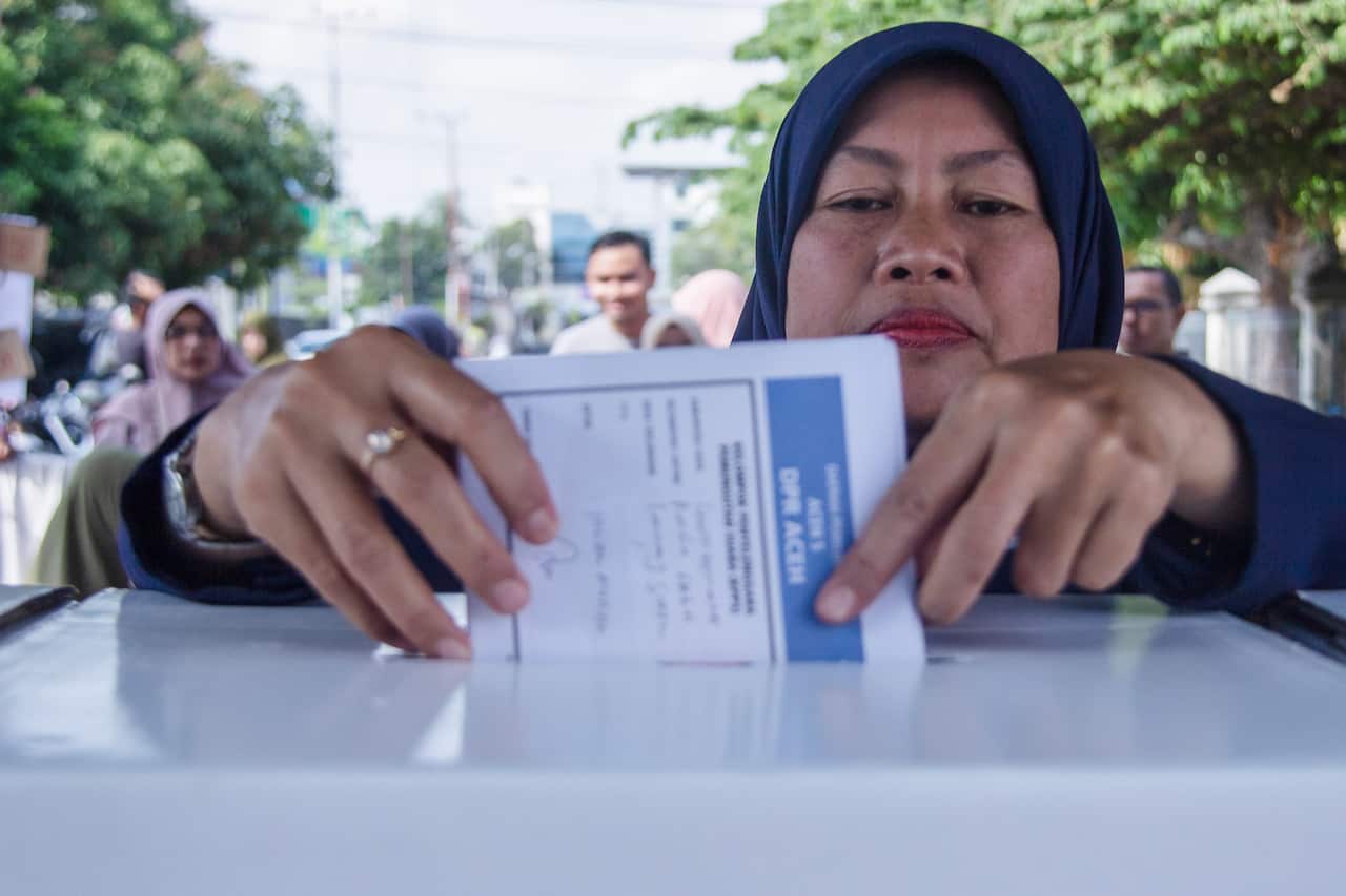 A resident casts their vote at a polling station on Election Day in Lhokseumawe, Aceh province, Indonesia.