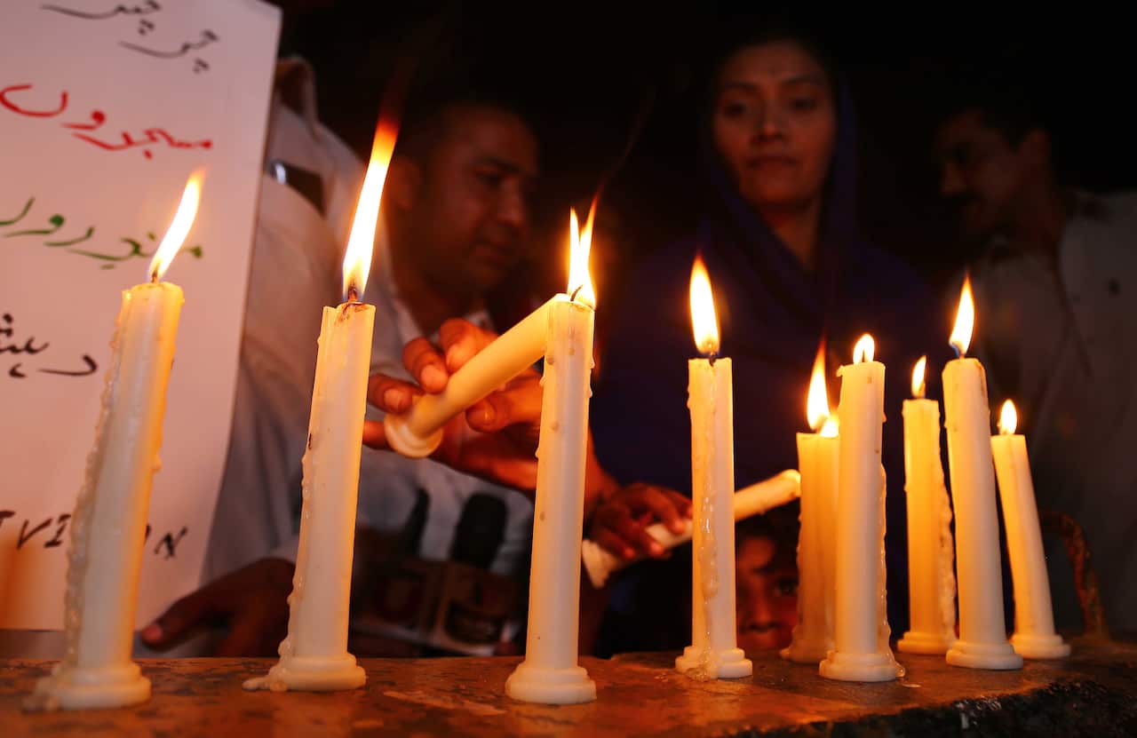 People light candles as they condemn the deadly bomb blasts in Sri Lanka, during a protest in Karachi, Pakistan.