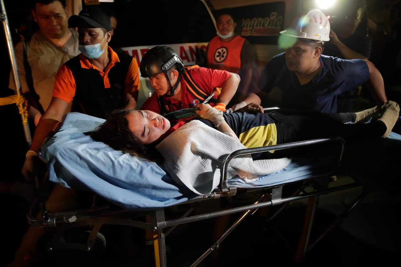 Emergency responders carry out an earthquake victim from a commercial building in Porac town, Pampanga Province.