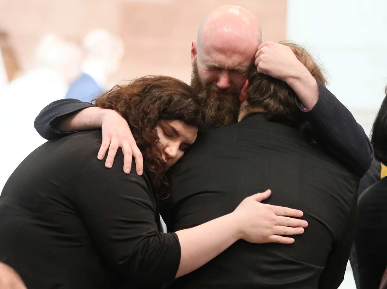 Mourners embrace at the funeral.