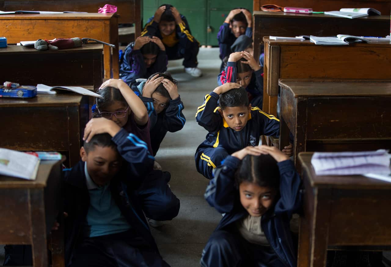 Nepalese school children crouch under their desk during an earthquake drill to mark the fourth anniversary of devastating earthquake.