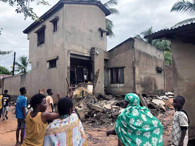 Residents of Nitate, Pemba, looking at a house that was damaged by floodwaters in northern Mozambique.