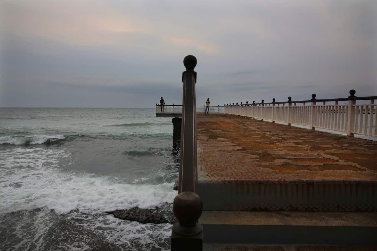 Sri Lankans stand at the deserted Galle face promenade jetty facing Indian ocean after the April blasts.