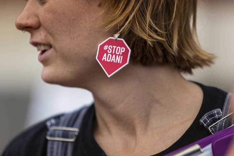 A woman wears 'STOP ADANI' earrings in Brisbane, Friday, May 3, 2019. 