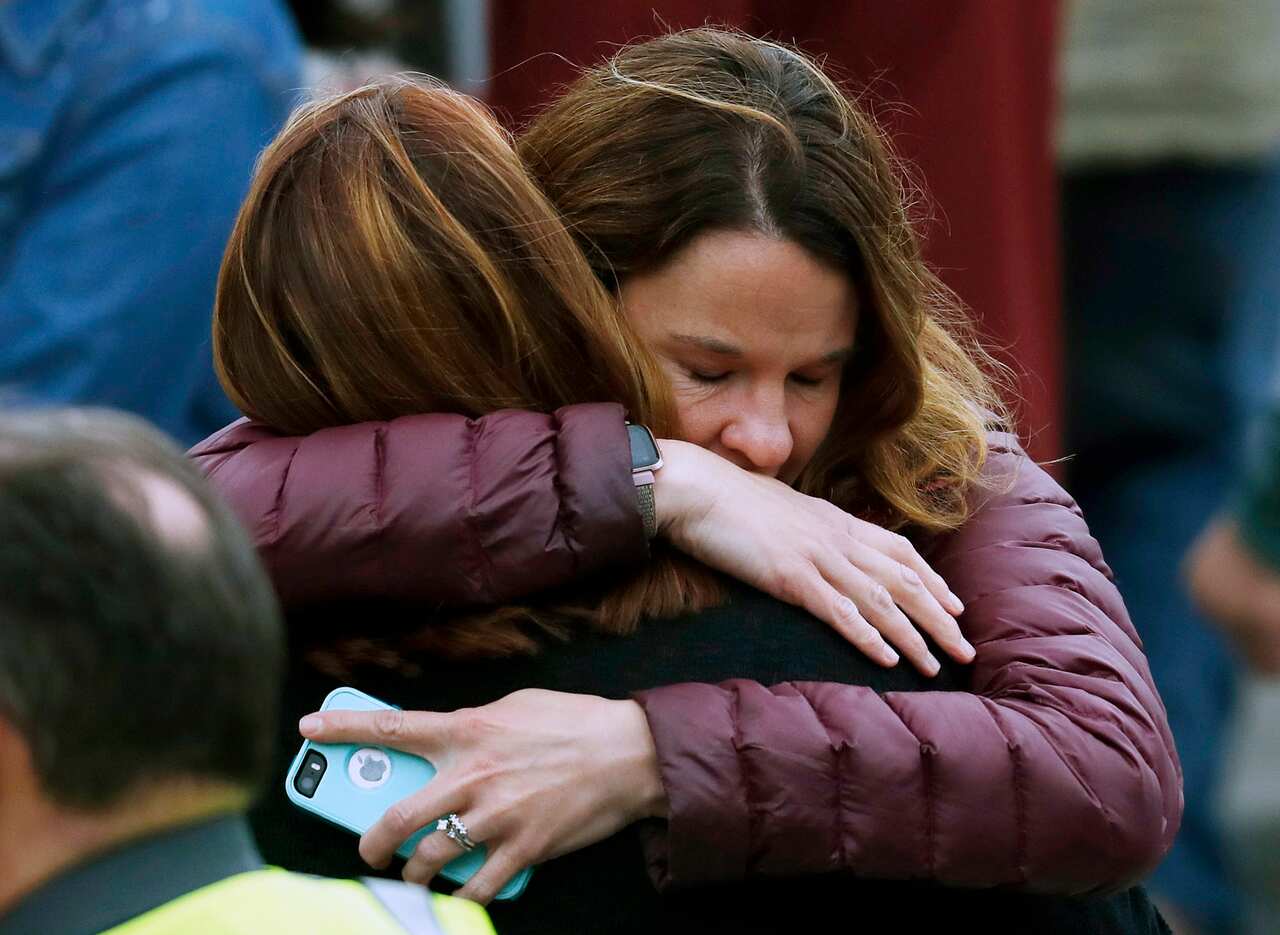 Parents hug as they wait for their children after a shooting at a suburban Denver school.