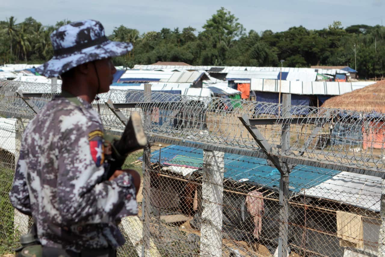 A Myanmar border guard stands to provide security near a fence at a no-man's land between Myanmar and Bangladesh, near Taungpyolatyar village.