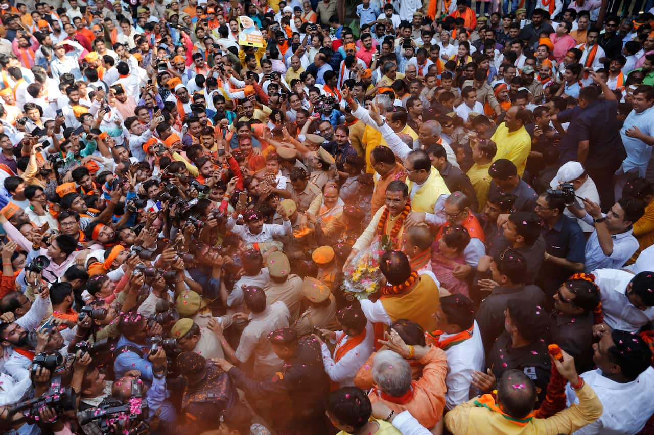BJP supporters greet Chief Minister of Uttar Pradesh state Yogi Adityanath as they celebrate the party's victory.