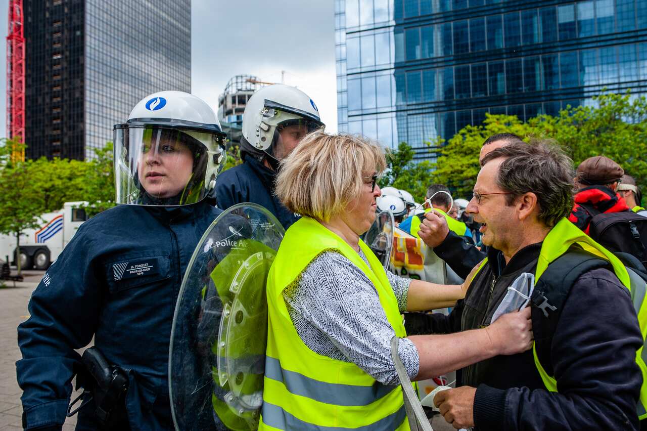 A yellow vest couple are passing by the riot police during the yellow vest demonstration that took place in Brussels during the European election.