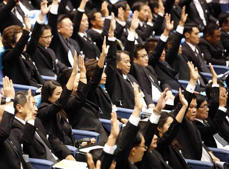 Some of the Thai members of the House raise their hands to support junta chief Prayut Chan-o-cha