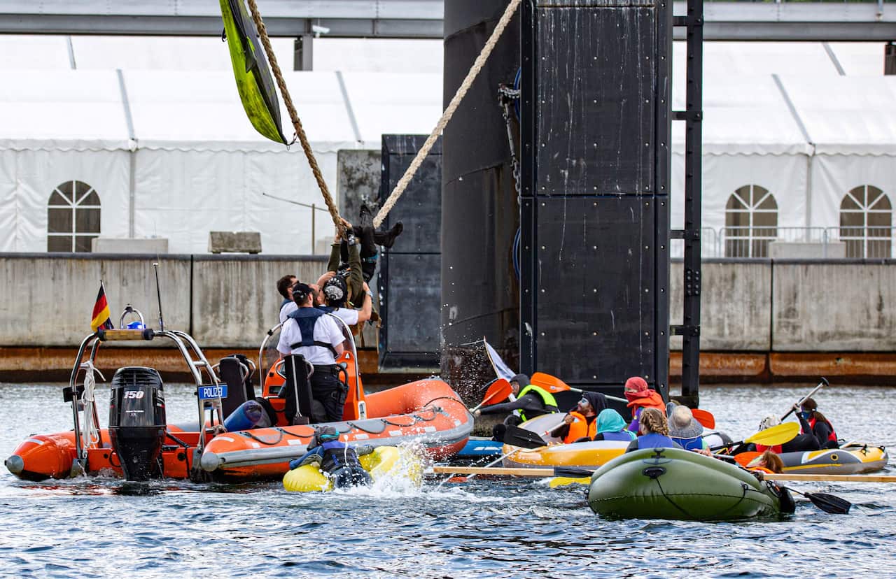 Police detain activists who try to prevent Holland America's cruise liner MS Zuiderdam from entering the port of Kiel, Germany.