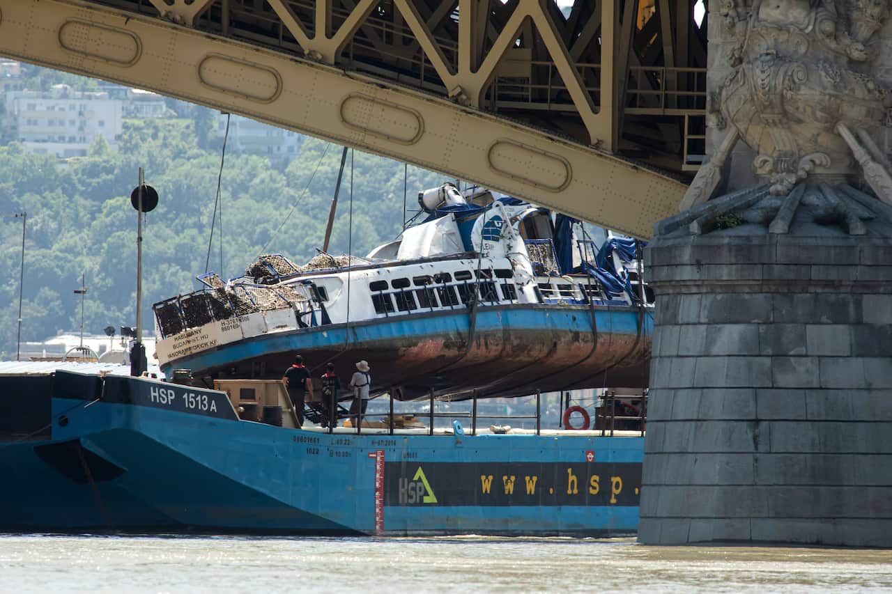 A crane places the wreckage of the sightseeing boat on a transporting barge at Margaret Bridge, the scene of the fatal boat accident in Budapest, Hungary.