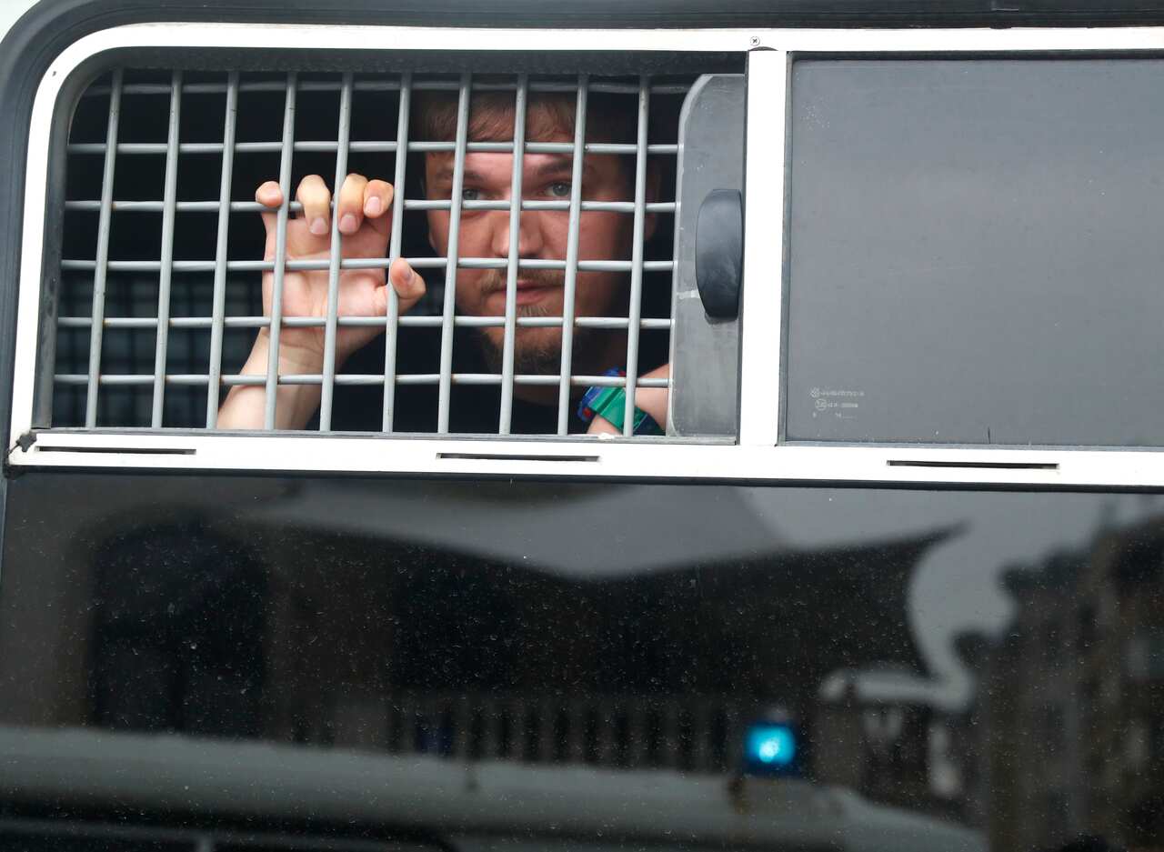 A detained protester looks out of a police bus window in Moscow.