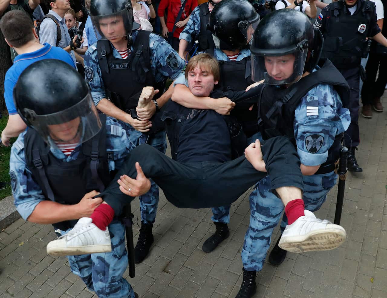 Police officers detain a protester during a march in Moscow, Russia.