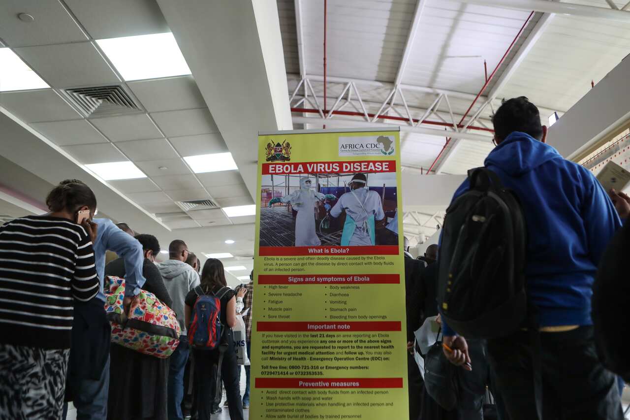 Travellers coming in from Uganda queue waiting to be screened for temperatures.