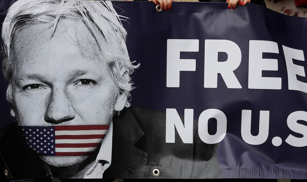 Assange supporters hold a banner to protest outside Westminster Magistrates Court in London, Friday, June 14, 2019. 