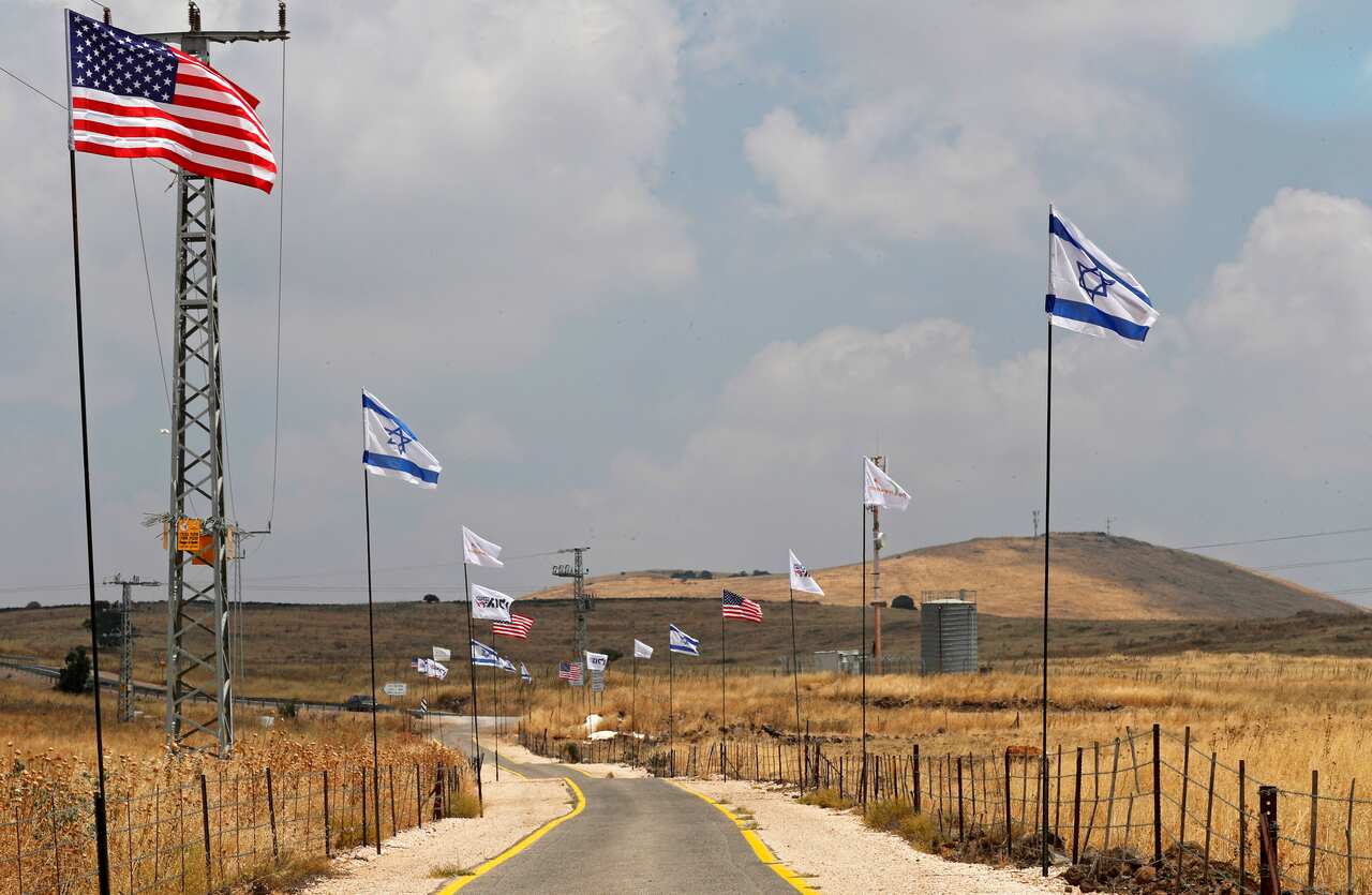 US and Israeli flags decorate the road leading to the Israeli settlement of Bruchim-Kela Alon, in the Golan Heights, 14 June 2019. 