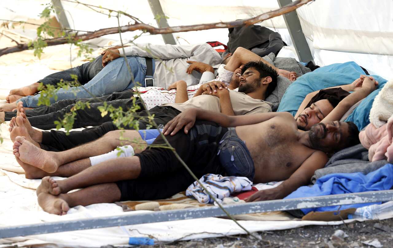 Migrants and refugees sit at a tent camp in Bihac, Bosnia and Herzegovina.