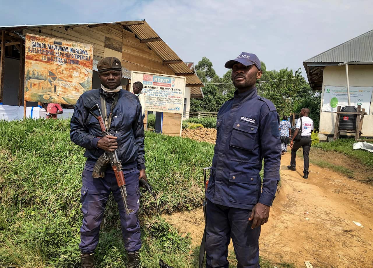 Congolese police guard a health center while Ebola vaccinations take place.