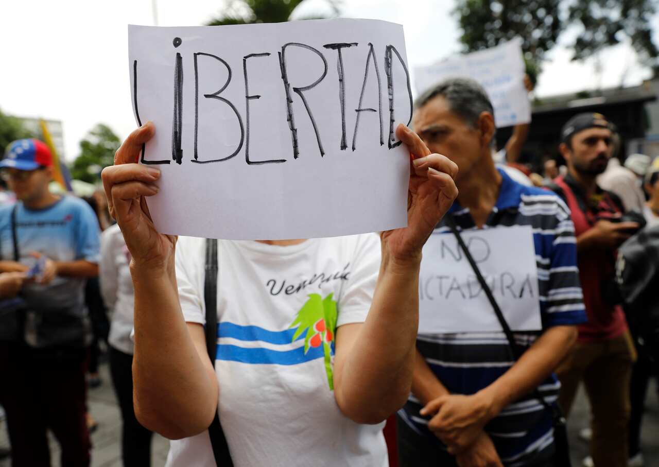 A woman holds up a sign that reads "freedom" in Spanish during a protest against the government of Nicolas Maduro.
