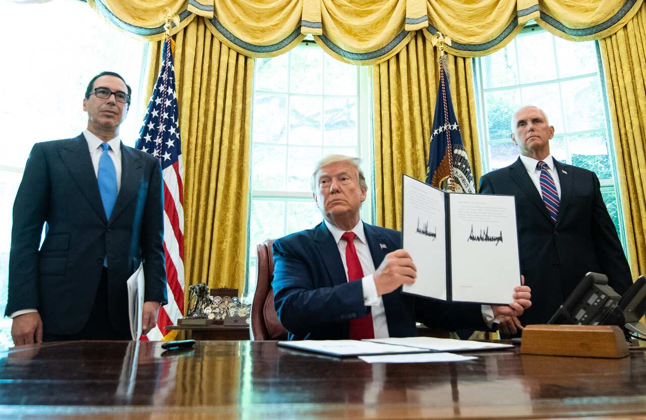 President Donald Trump holds up a copy of an executive order for additional sanctions against Iran and its leadership.