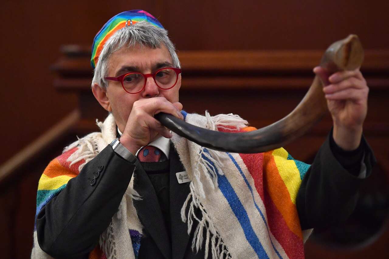 Rabbi Jonathan Keren-Black uses a rabbinical horn (shofar) to sound the end of the era of coal.