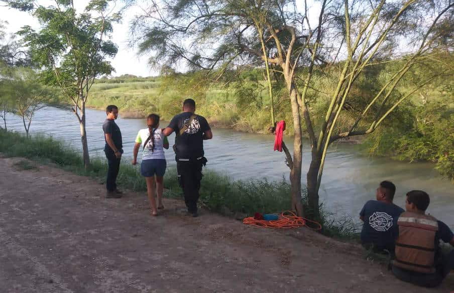 Tania Valos, center left, is assisted by Mexican authorities after her husband and two-year-old daughter were swept away while trying to cross the Rio Grande