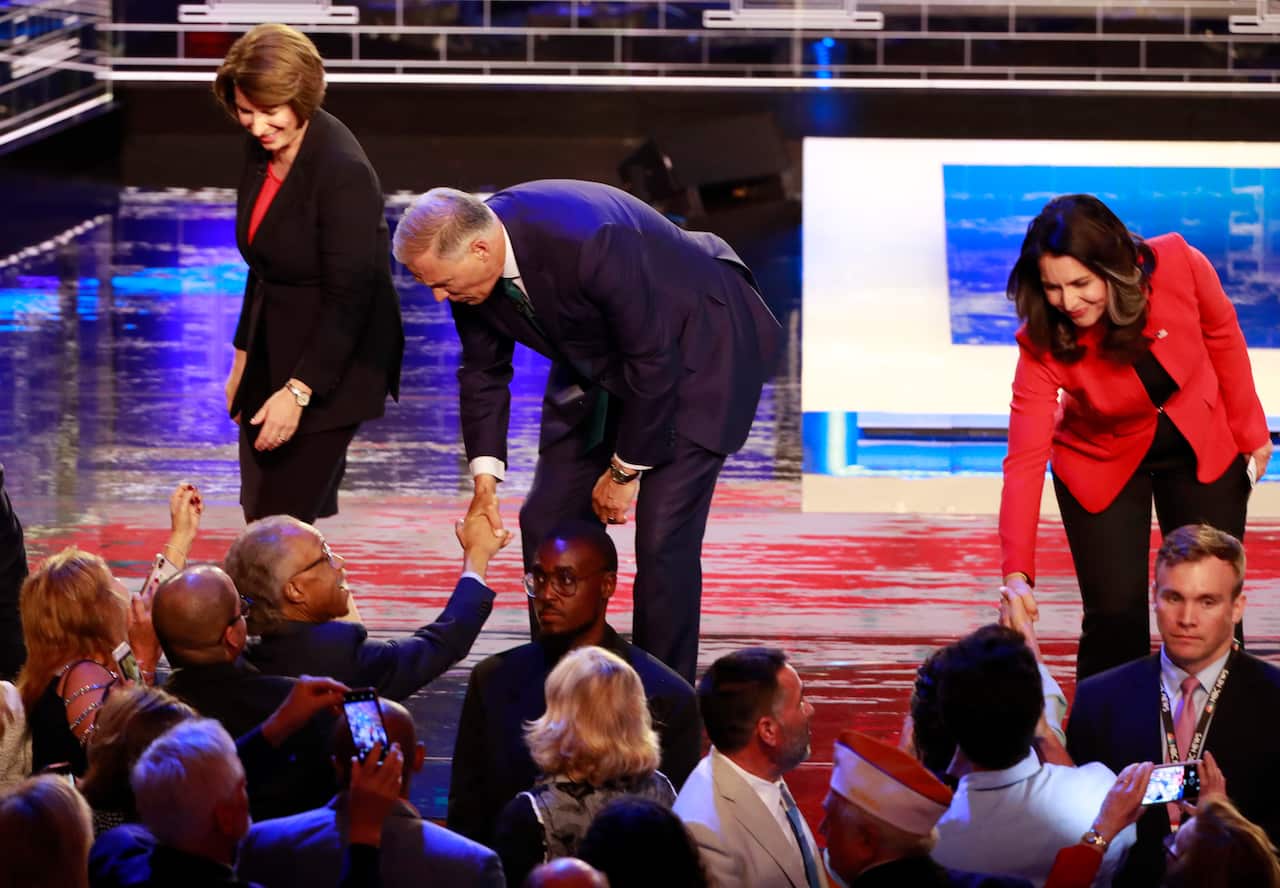 Democratic candidates Senator Amy Klobuchar, Washington Govenor Jay Inslee and Representative Tulsi Gabbard greet supporters at the end of the debate.