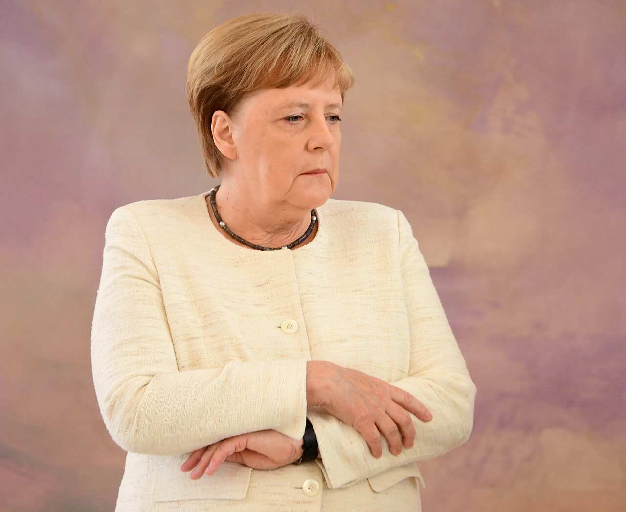 German Chancellor Angela Merkel grips her arms during her second bout of the shakes. 