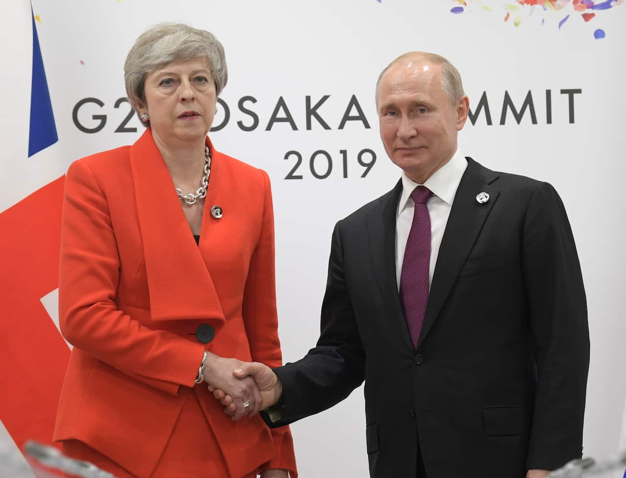 British Prime Minister Theresa May and Russian President Vladimir Putin shake hands. 