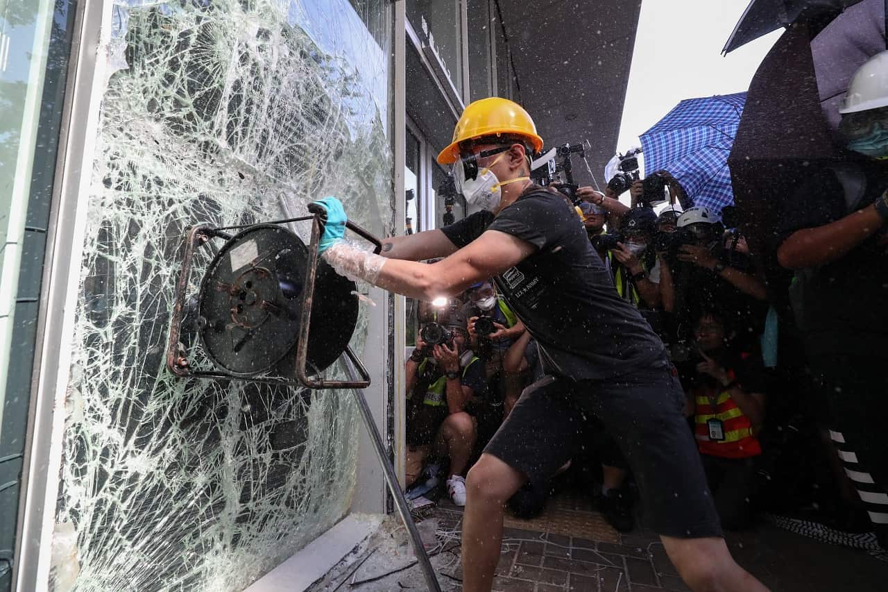 A protester breaks a window of the Legislative Council.