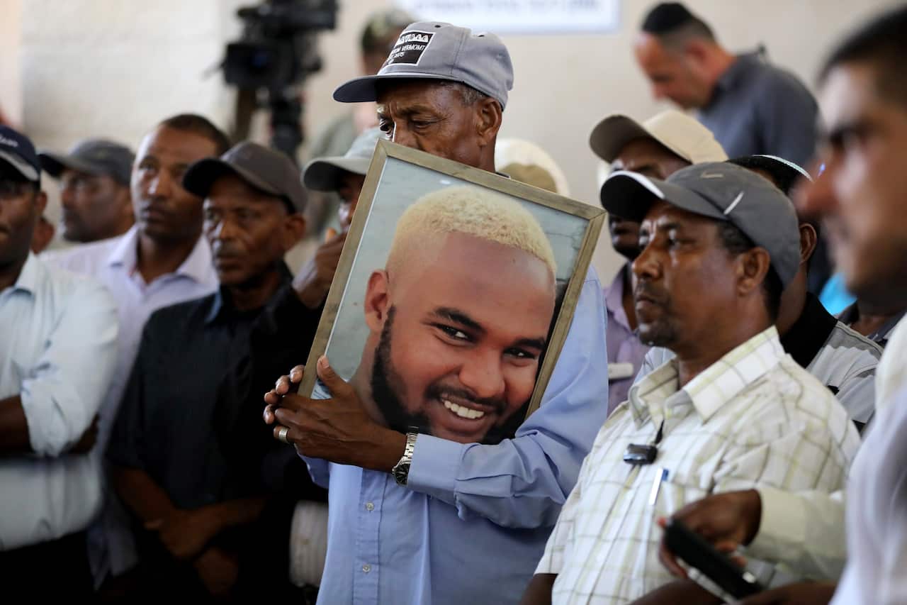 Family members and friends hold a picture and mourn Solomon Tekah, Israel, 02 July 2019.
