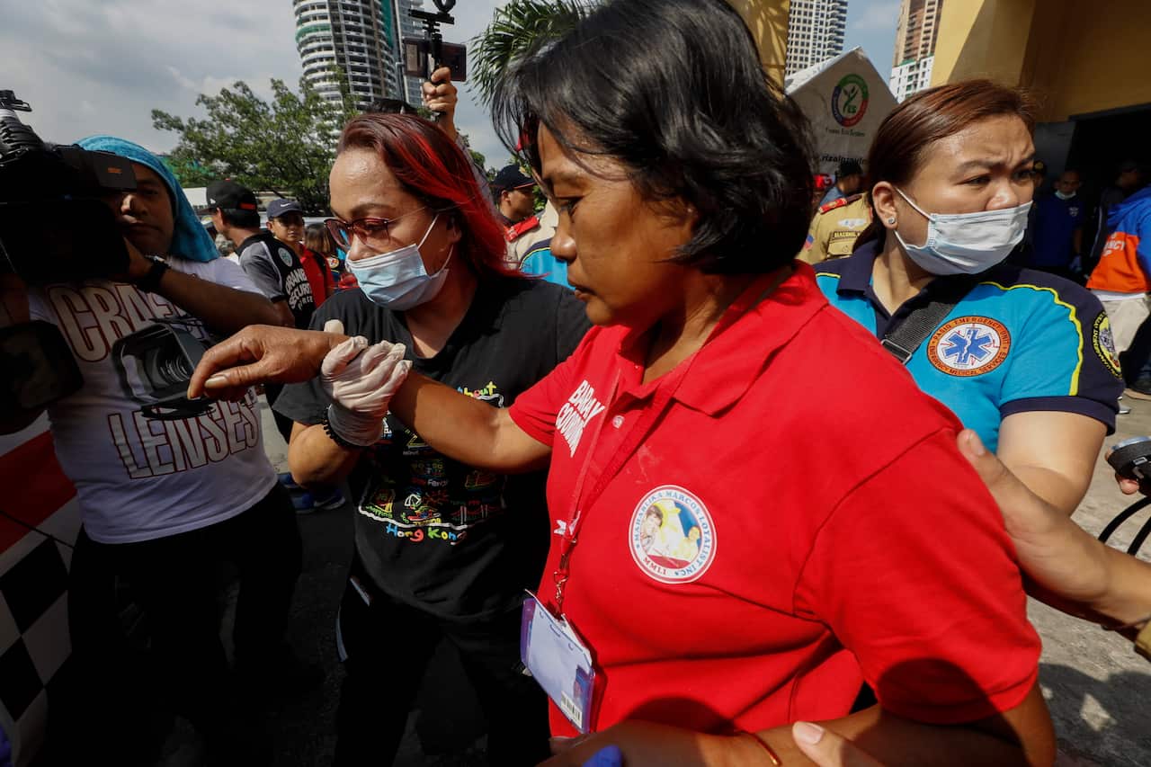 A party guest is assisted to a waiting ambulance after falling ill with suspected food poisoning.
